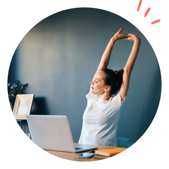 en dam sitter på sitt kontor och sträcker på sig