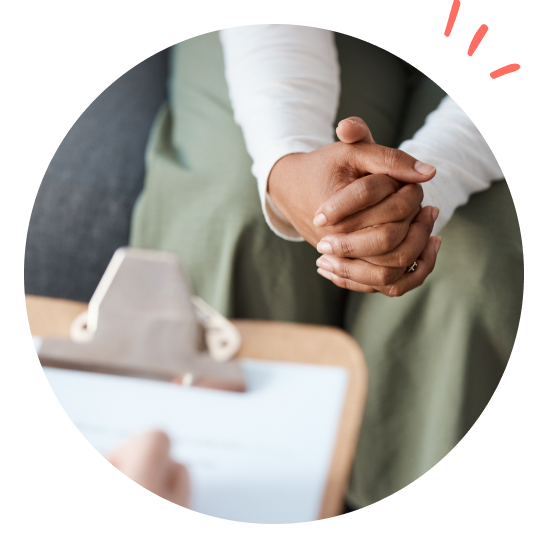 en person sitter med knäppta händer under en undersökning