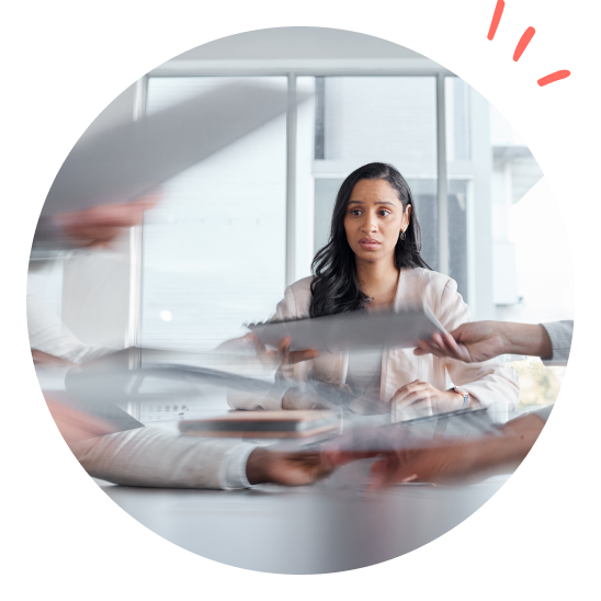 en dam sitter i ett möte där alla vill ha hennes uppmärksamhet samtidigt