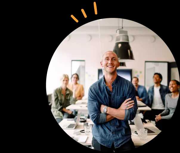 Mann foran et bord med ansatte på et kontor.